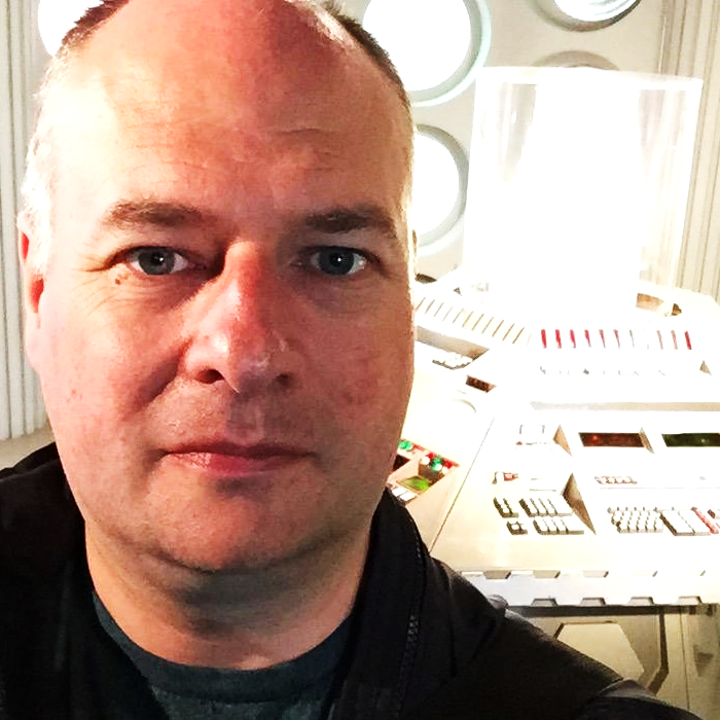 Close-up of a man with short hair in the Tardis.