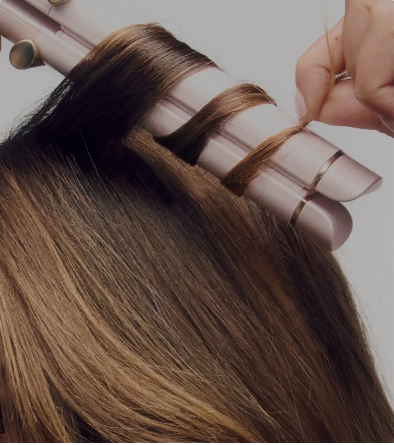 Close-up of a person getting their hair colored, with a section of hair being held and wrapped in foil.