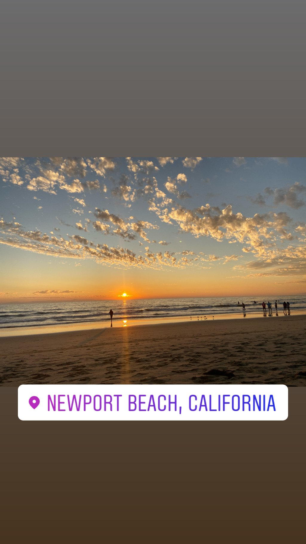 Sunset along the shoreline at Newport Beach, California, near the Balboa Peninsula with people enjoying the beach.