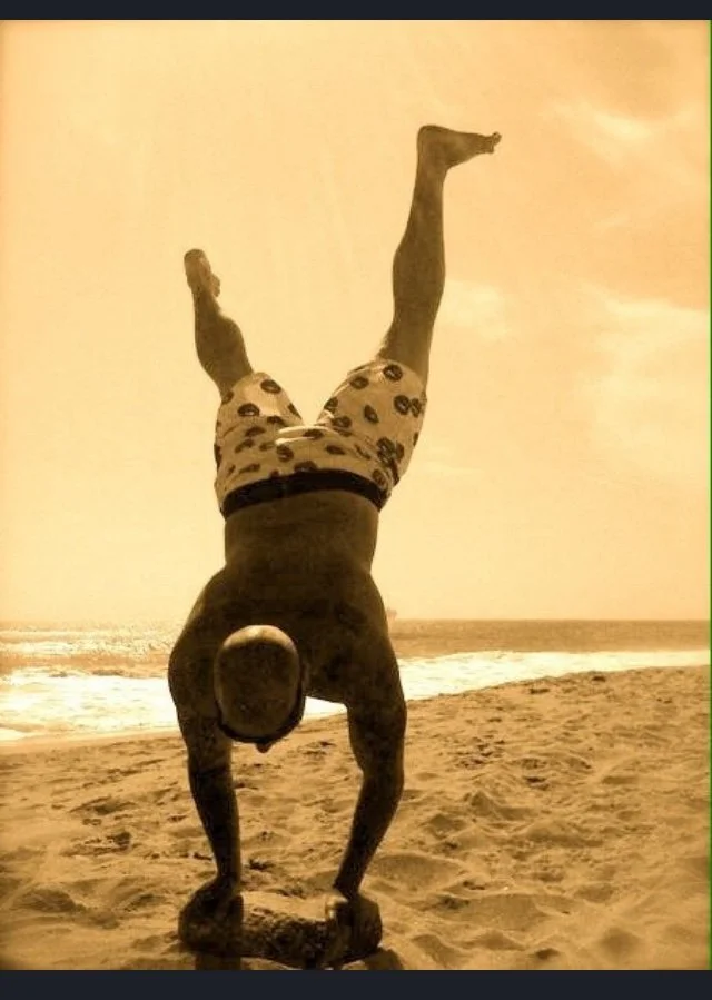 person doing handstand on the beach in huntington beach california at sunset