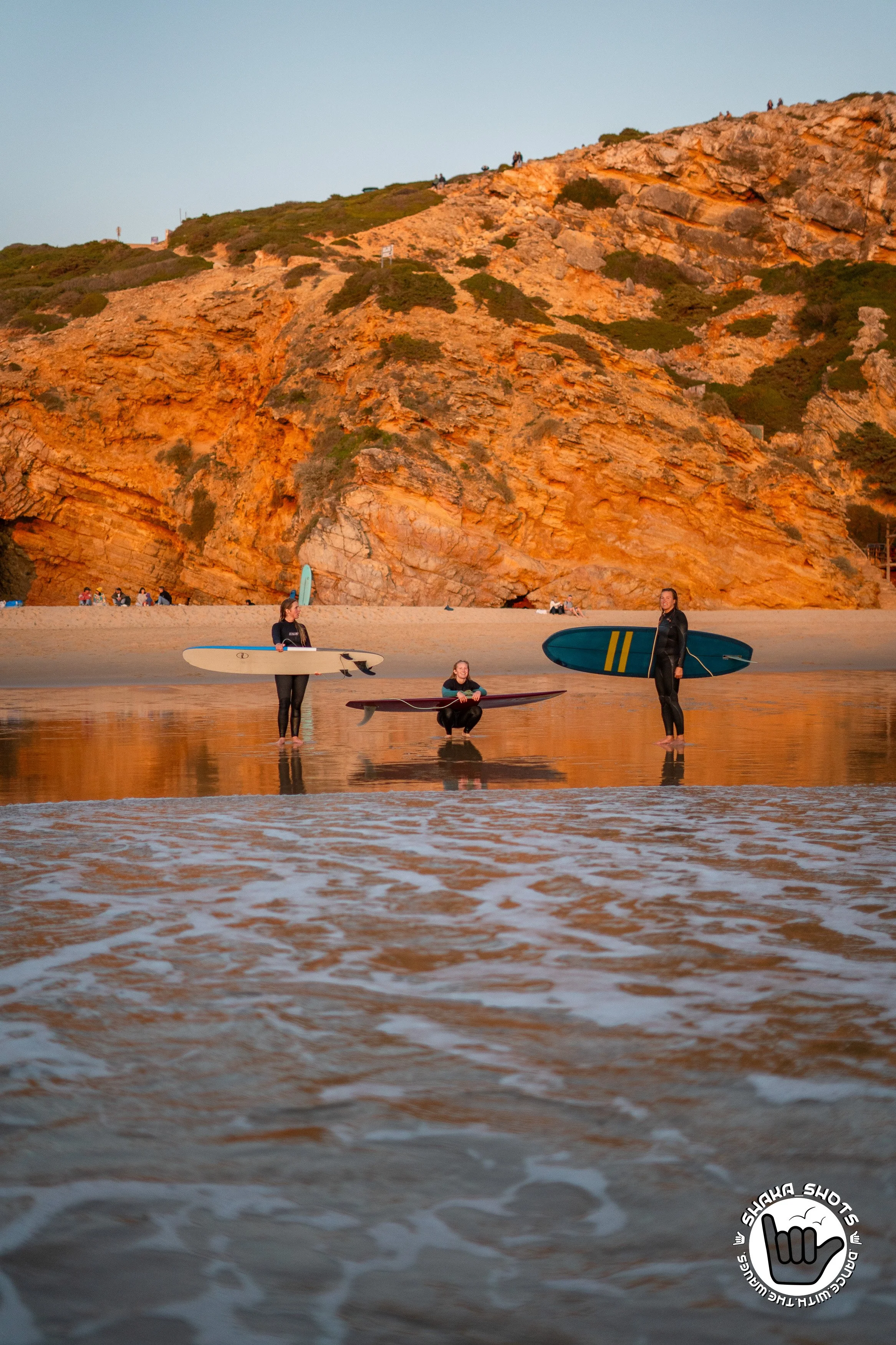 Sanne, Charlene en Hester met hun surfboarden op het strand in Portugal
