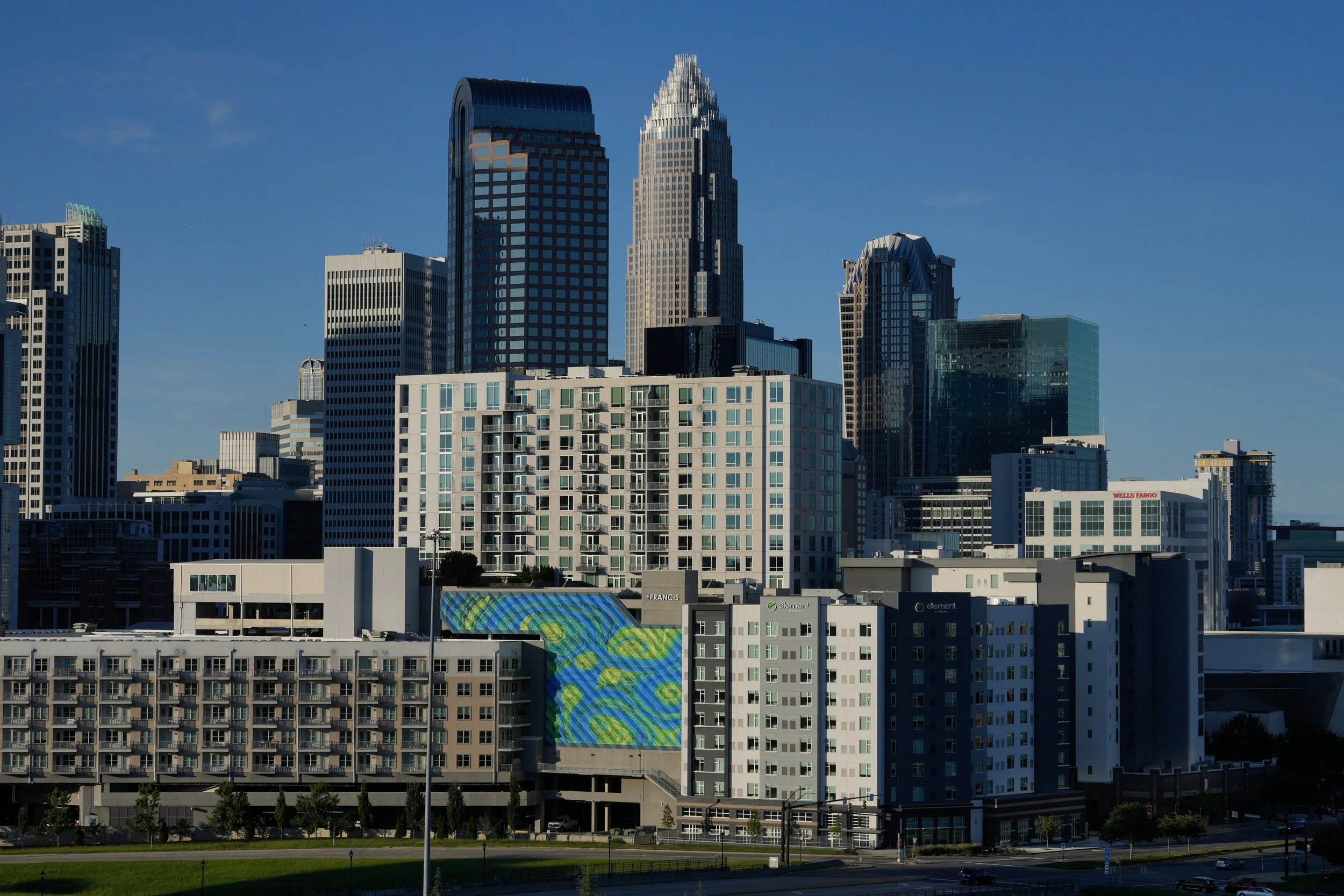 City skyline with various modern high-rise buildings against a clear blue sky.