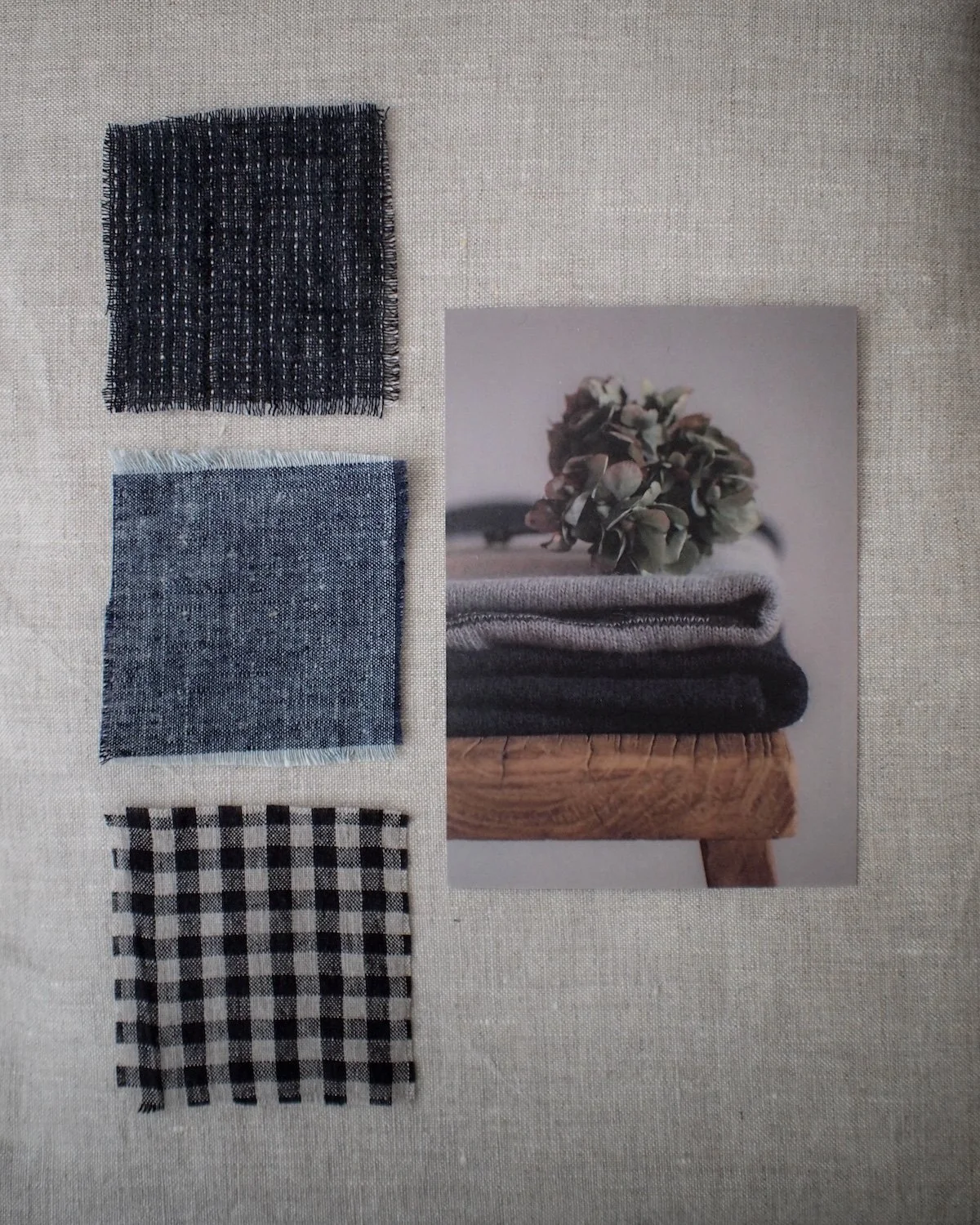 Three fabric swatches in different patterns and colors arranged beside a photograph of stacked folded clothes and dried flowers.
