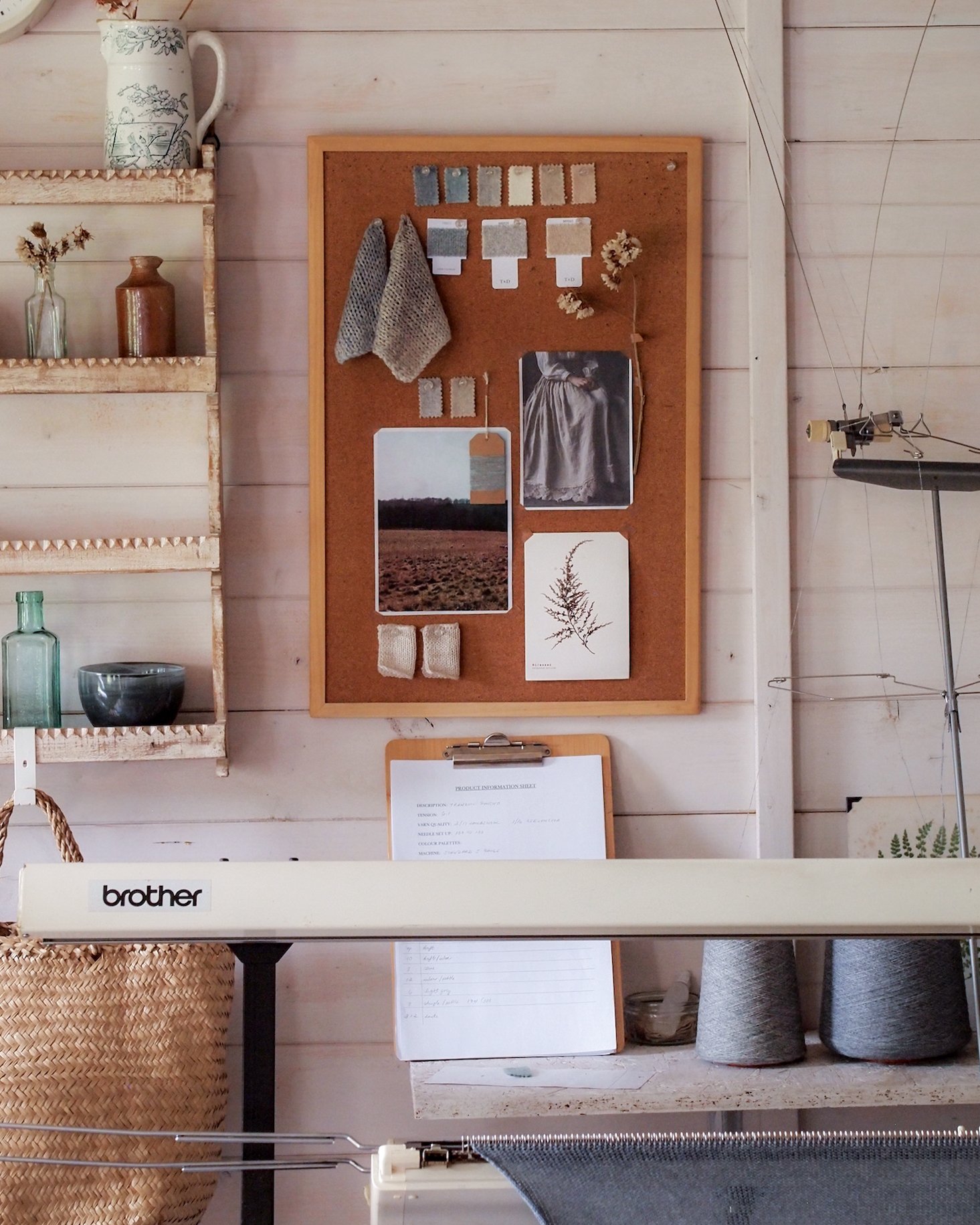 studio view with knitting machine, inspiration board and shelf with vintage bottles.