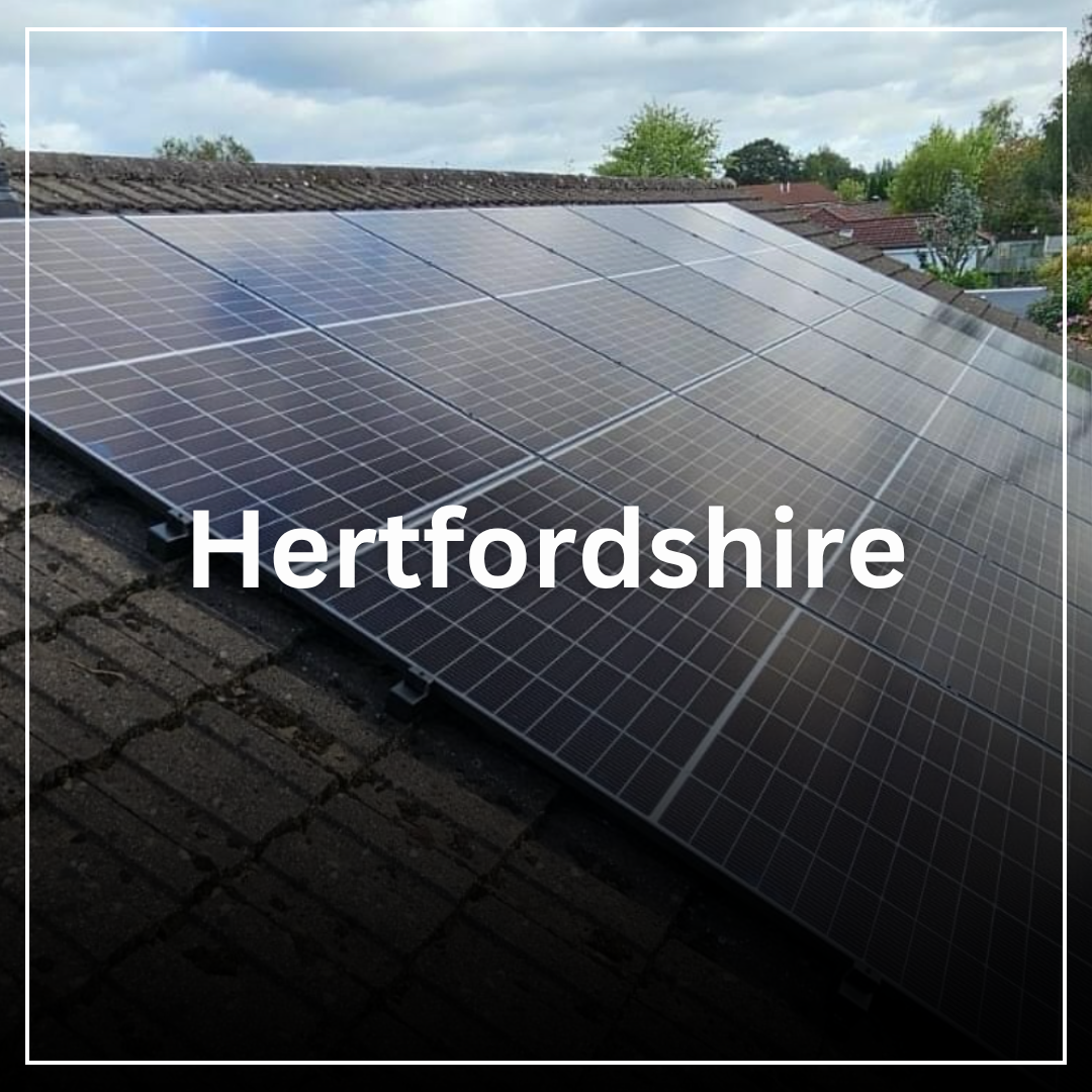 Solar panels installed on a rooftop with trees and houses in the background in Hertfordshire.