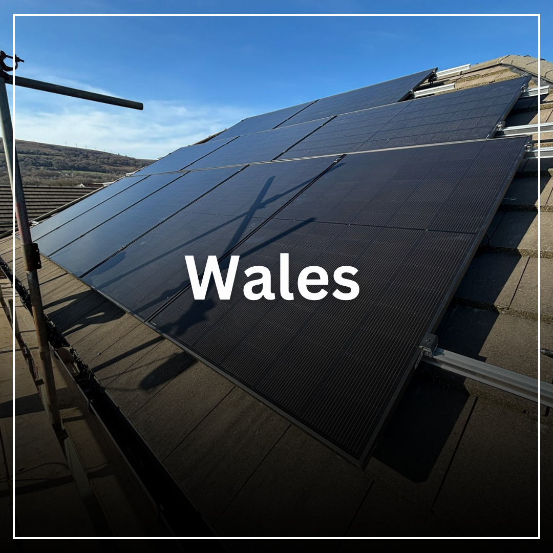 Solar panels installed on a rooftop in Wales under a clear blue sky.