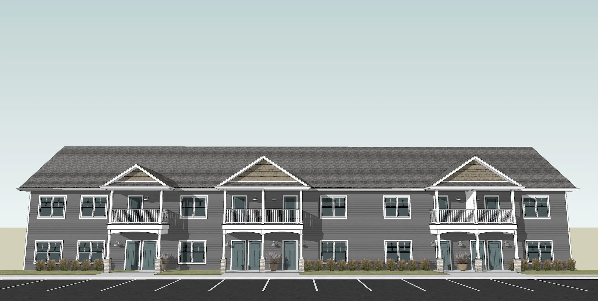 Front view of a multi-story residential building with gray siding, multiple windows, and small balconies, set against a clear sky.