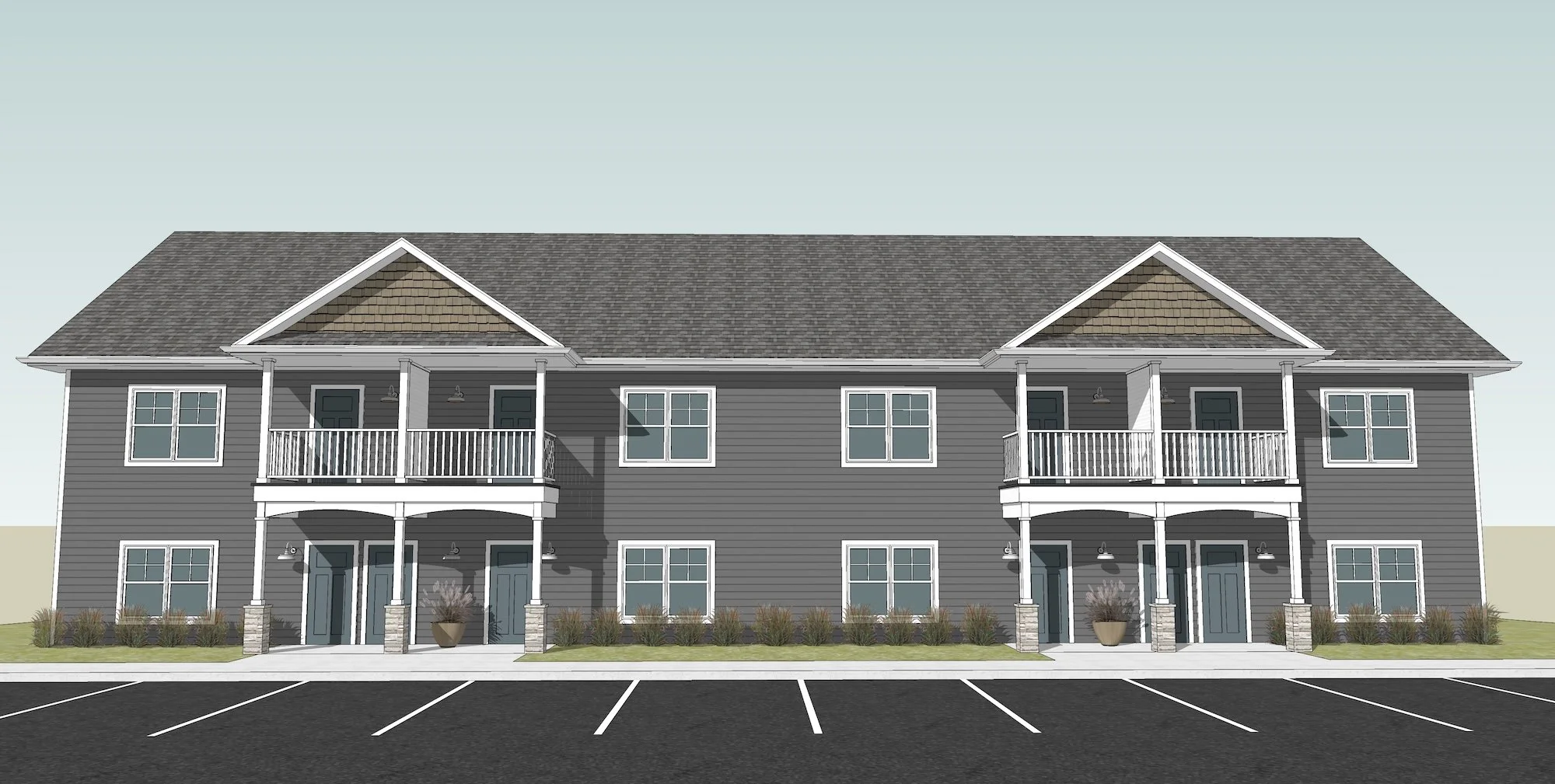 Two-story residential building with a grey exterior, white trim, and multiple balconies, surrounded by landscaping and an asphalt parking lot in front.