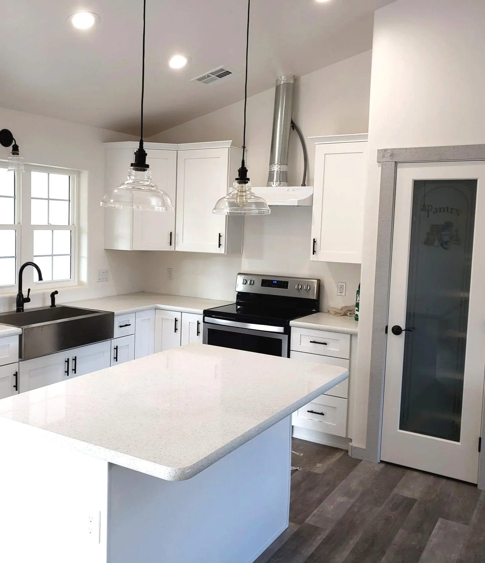 Gator Home Services- Payson- kitchen with white cabinets, quarts countertops, a generic hood vent and pipe showing