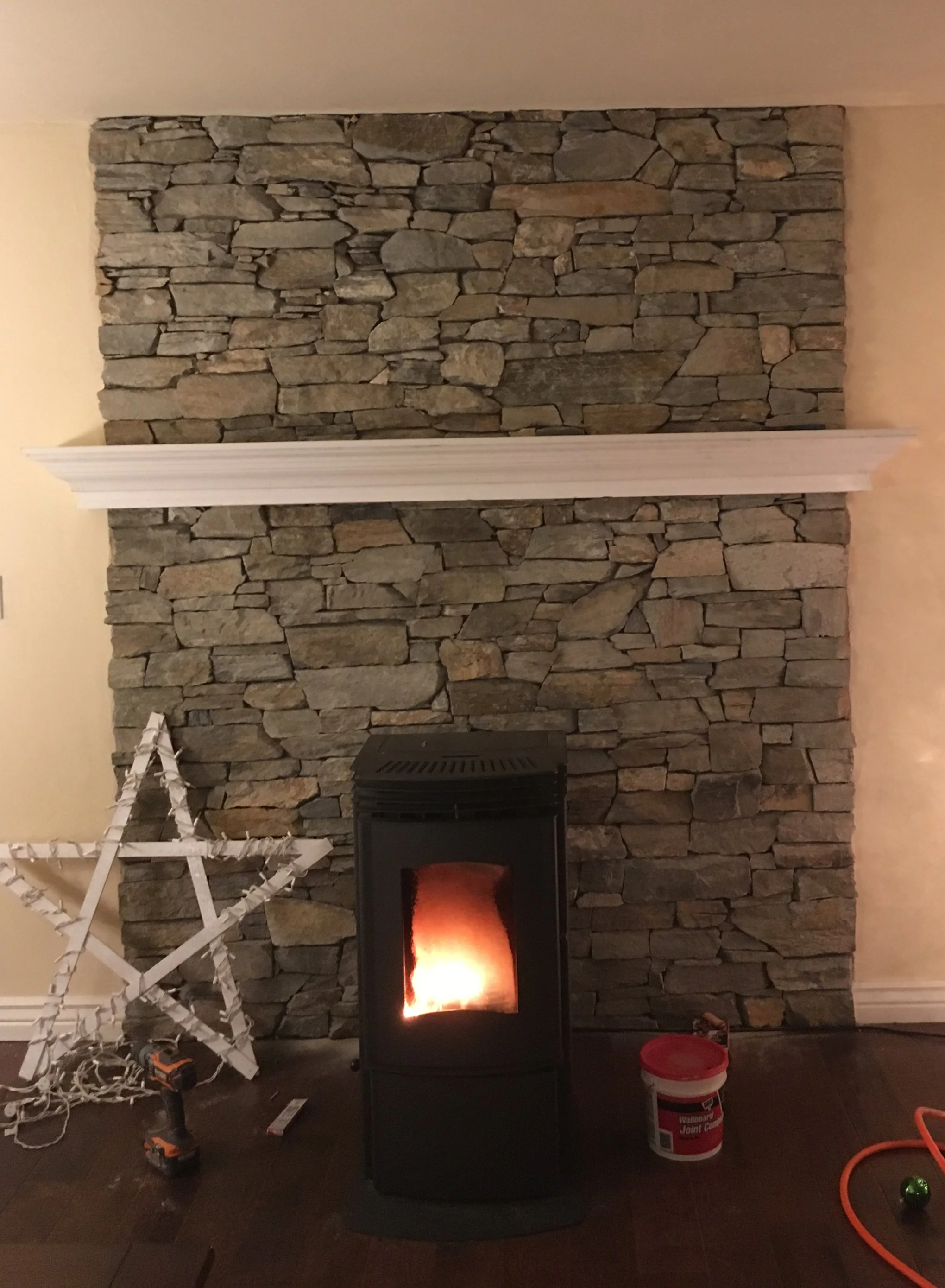 Gator's Home Services- Payson, AZ - Hand Built Mantel on stonework behind pellet stove
