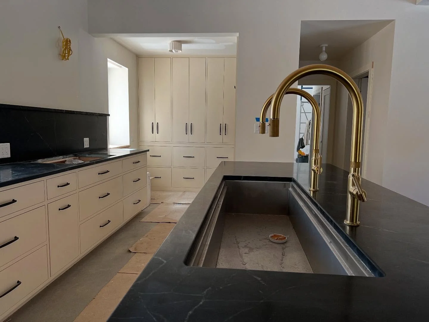 A sleek modern kitchen for a eco conscience Croft home in Freeport. Painted Manchester tan with black pulls to accent the dark countertops. The homeowners were a dream to work with!