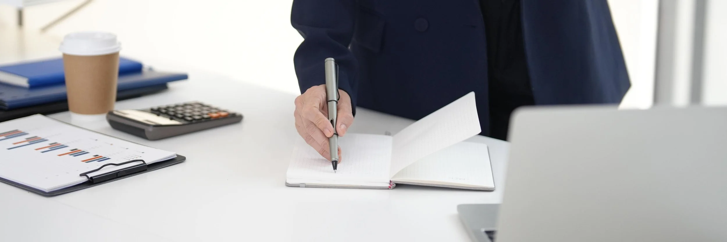 A financial planner outlining strategic goals and cash flow analysis in a notebook during a consulting engagement.