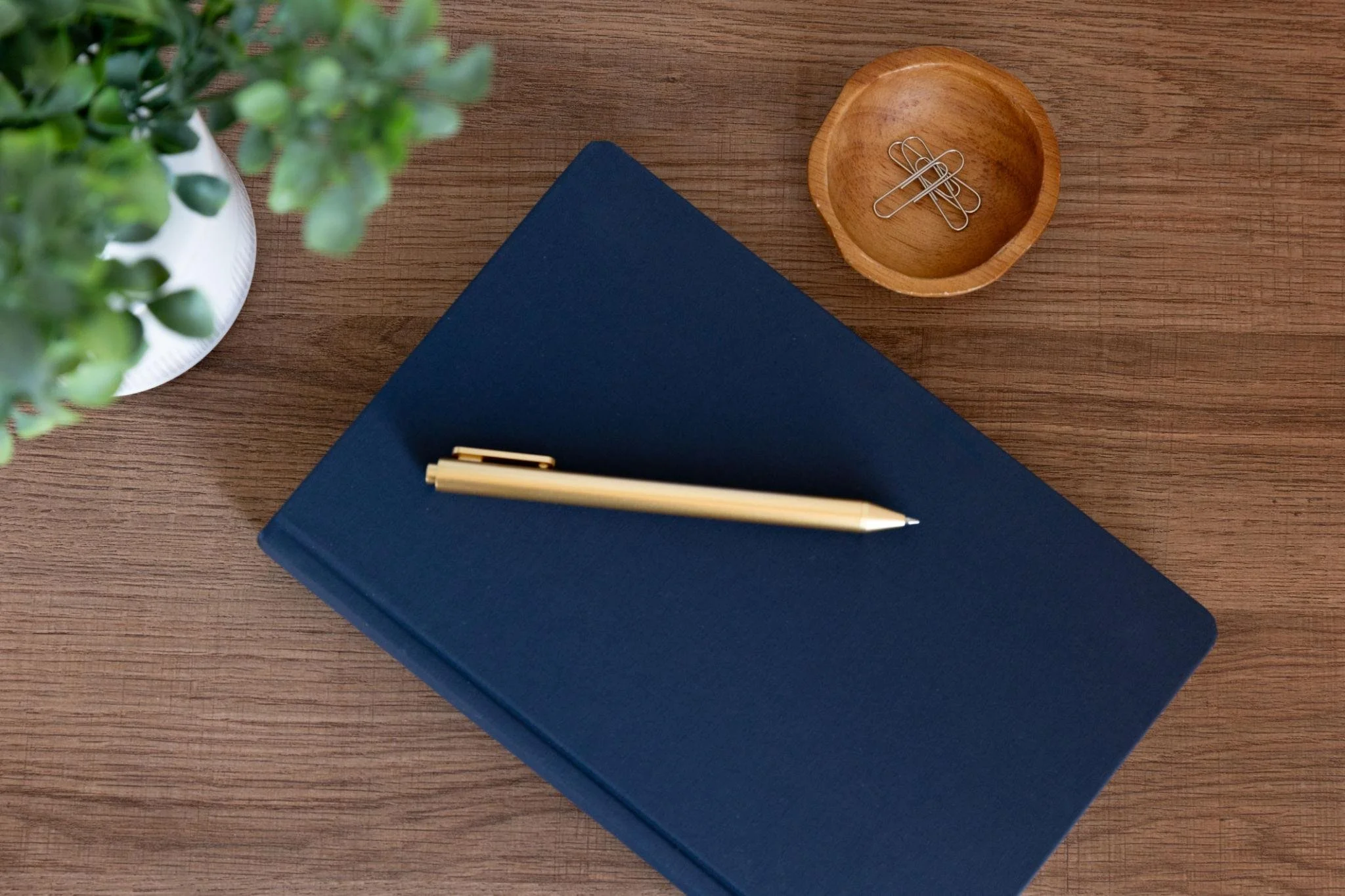 A clean professional workspace with a notebook and pen, representing specialized portfolio recommendations and fee-only financial consulting.