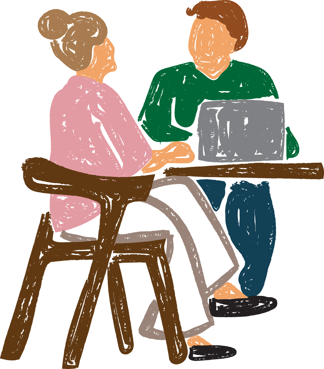 Two people sitting at a table, a man is working on laptop while listening to a woman speak.