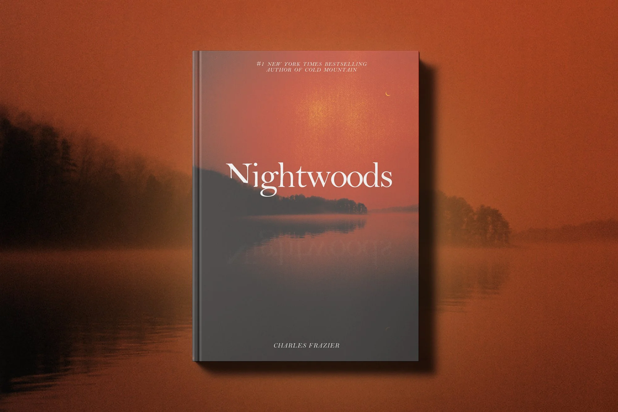 A book titled 'Nightwoods' by Charles Frazier stands against a blurred fiery sunset with dark trees and water in the background.