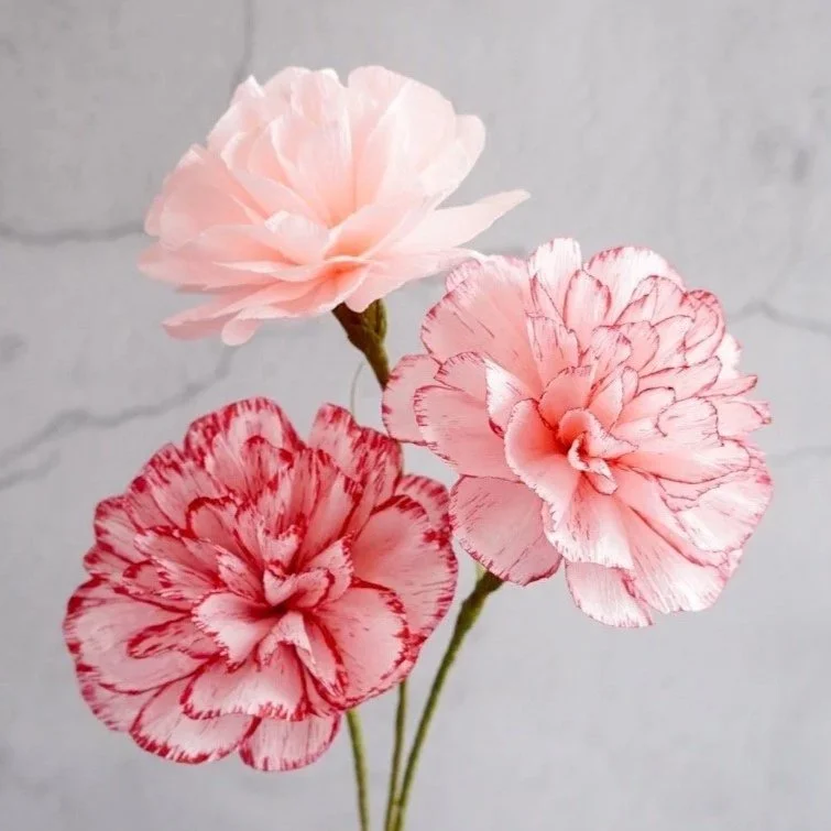 Three realistic carnations with pink and red petals handmade by Jasmine Sing, paper artist from Merremade.