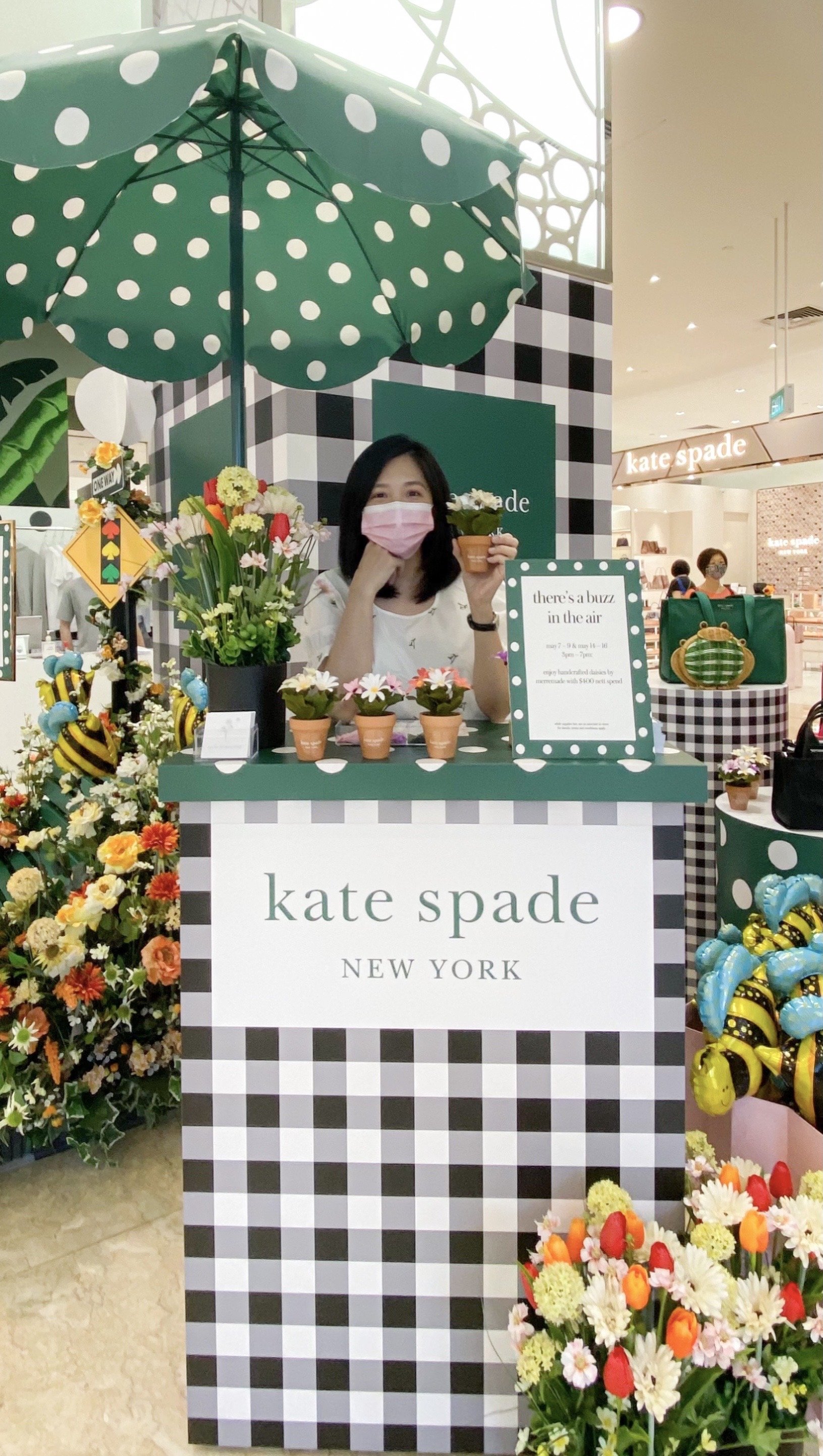Jasmine Sing, paper artist from Merremade  standing at a paper floral display booth for Kate Spade Singapore.