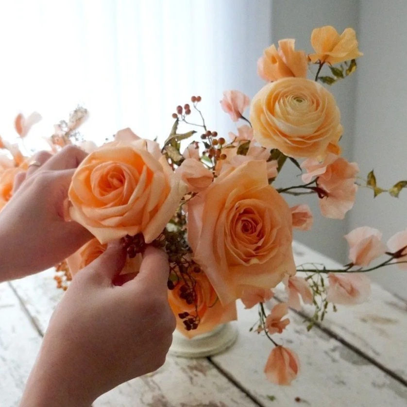 Jasmine Sing, paper artist arranging handmade realistic paper flowers with real flowers.