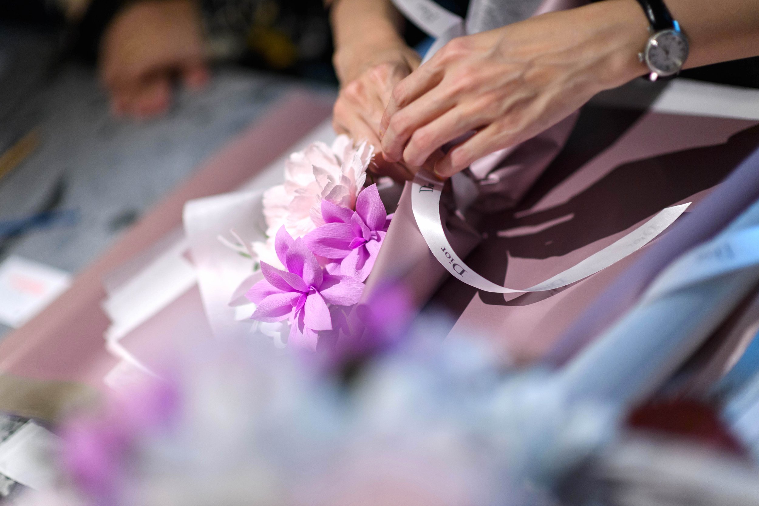 Close-up of Jasmine Sing from Merremade arranging pink and purple paper flowers.