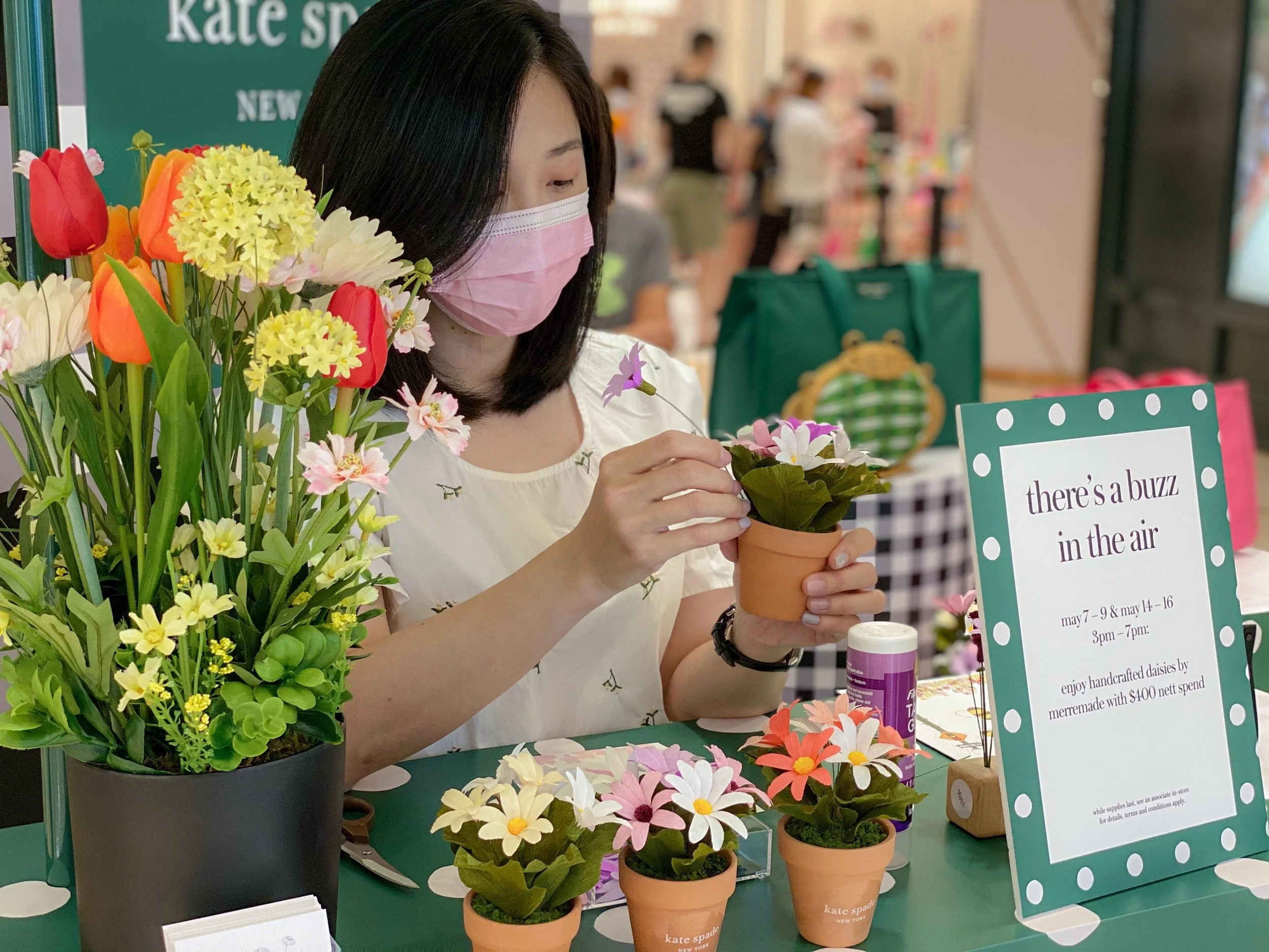Jasmine Sing, paper artist arranges colorful paper flowers during a live demonstration at a Kate Spade New York, Singapore pop up event.
