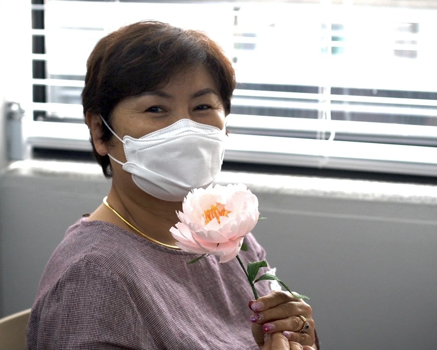Merremade student in her 60s showing off her lovely handmade paper peony.