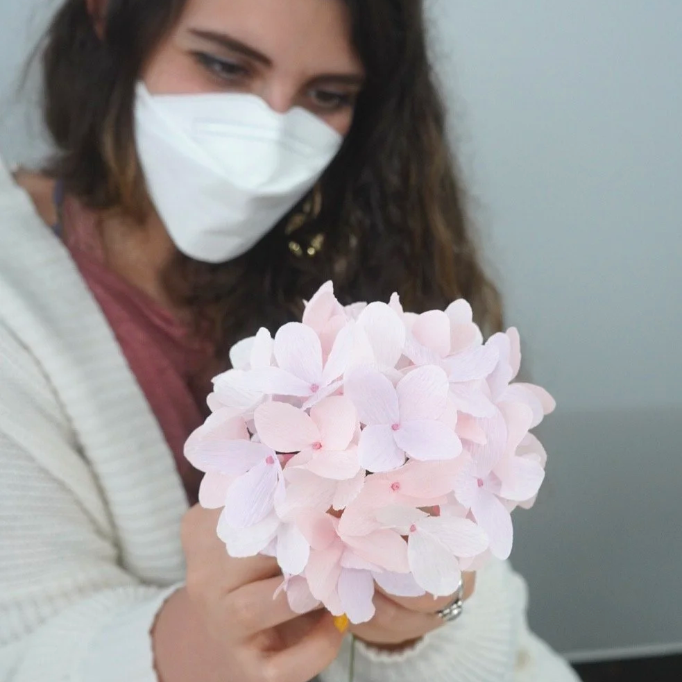 Merremade student holding a cluster of handmade pink paper hydrangea flowers during in-person workshop in Seoul, Korea.
