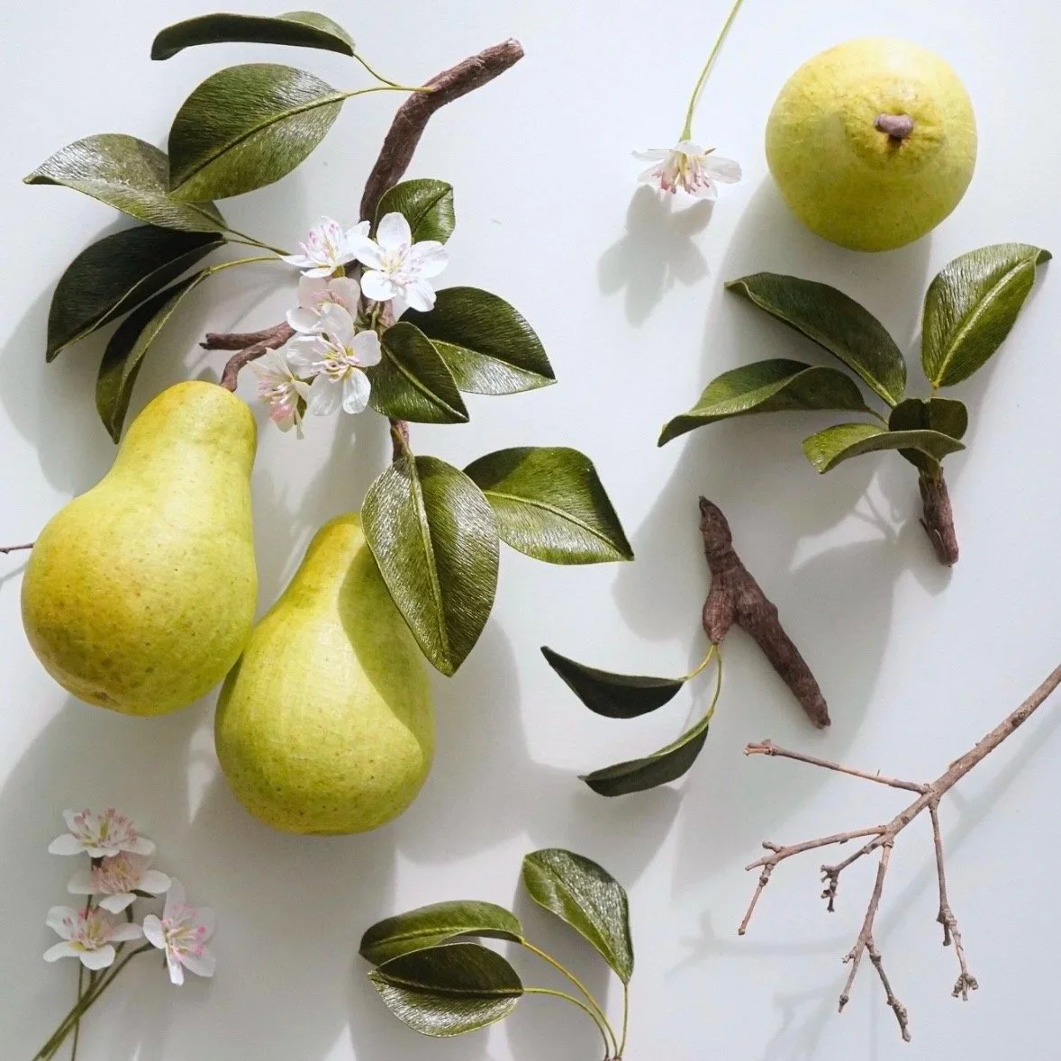 A group of realistic paper pears and branches handmade by Jasmine Sing, paper artist from Merremade.