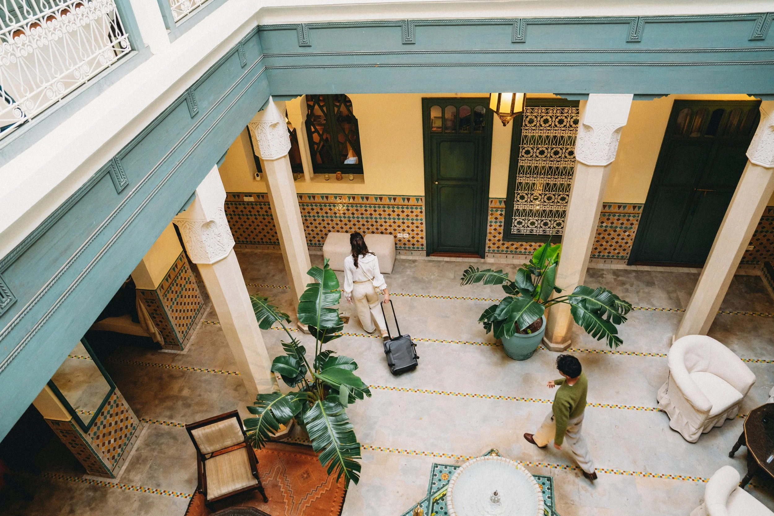 courtyard with people walking through with suitcase