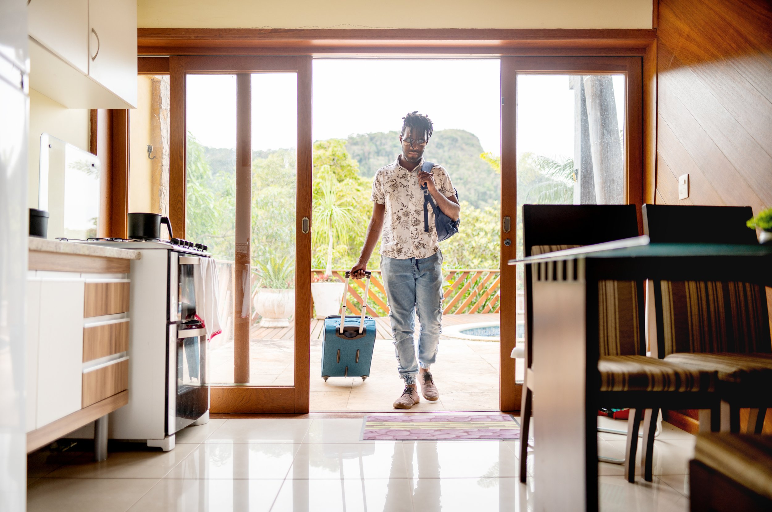 man enters vacation rental with suitcase