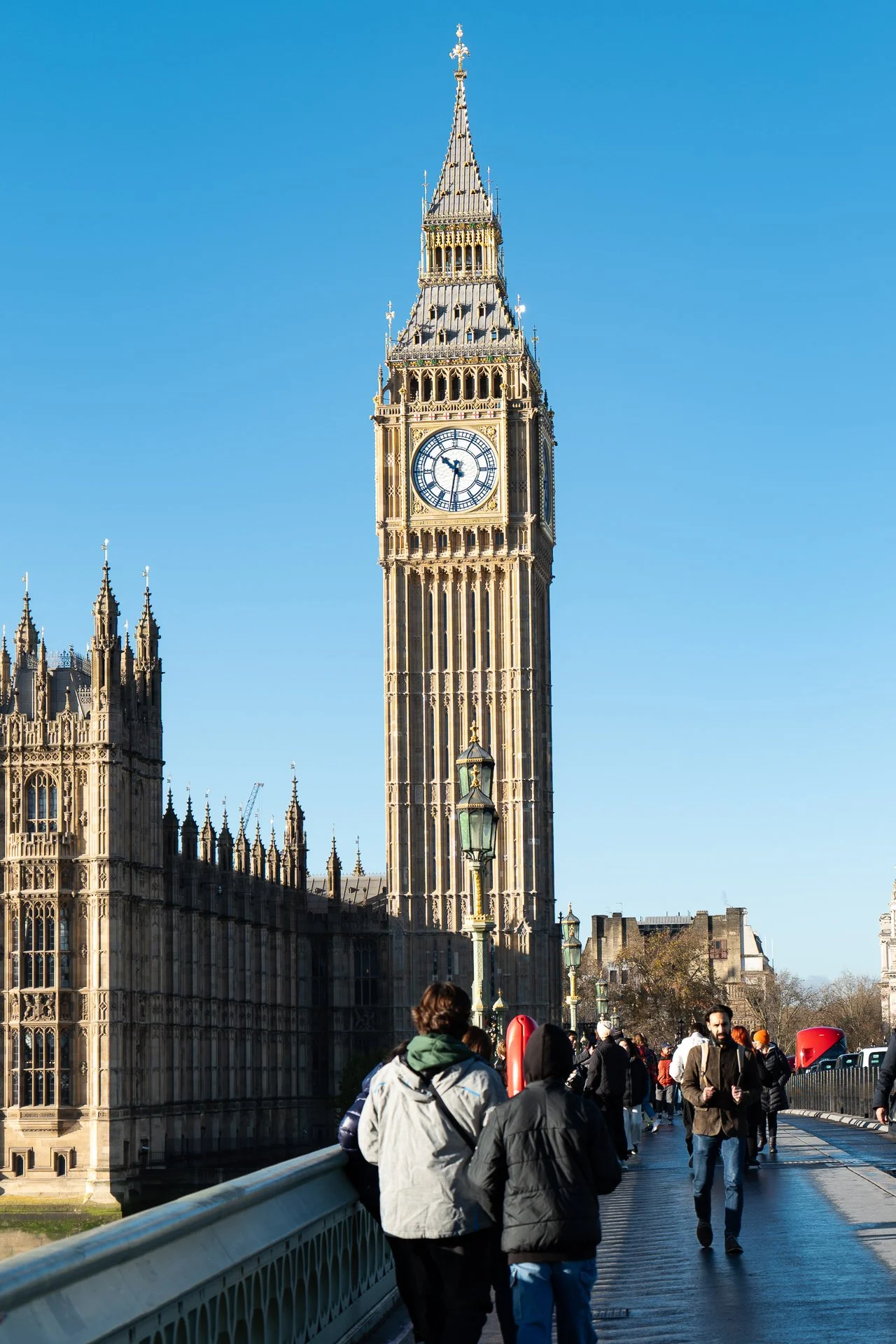 Clock tower, Westminster Bridge, London; pedestrians in foreground.