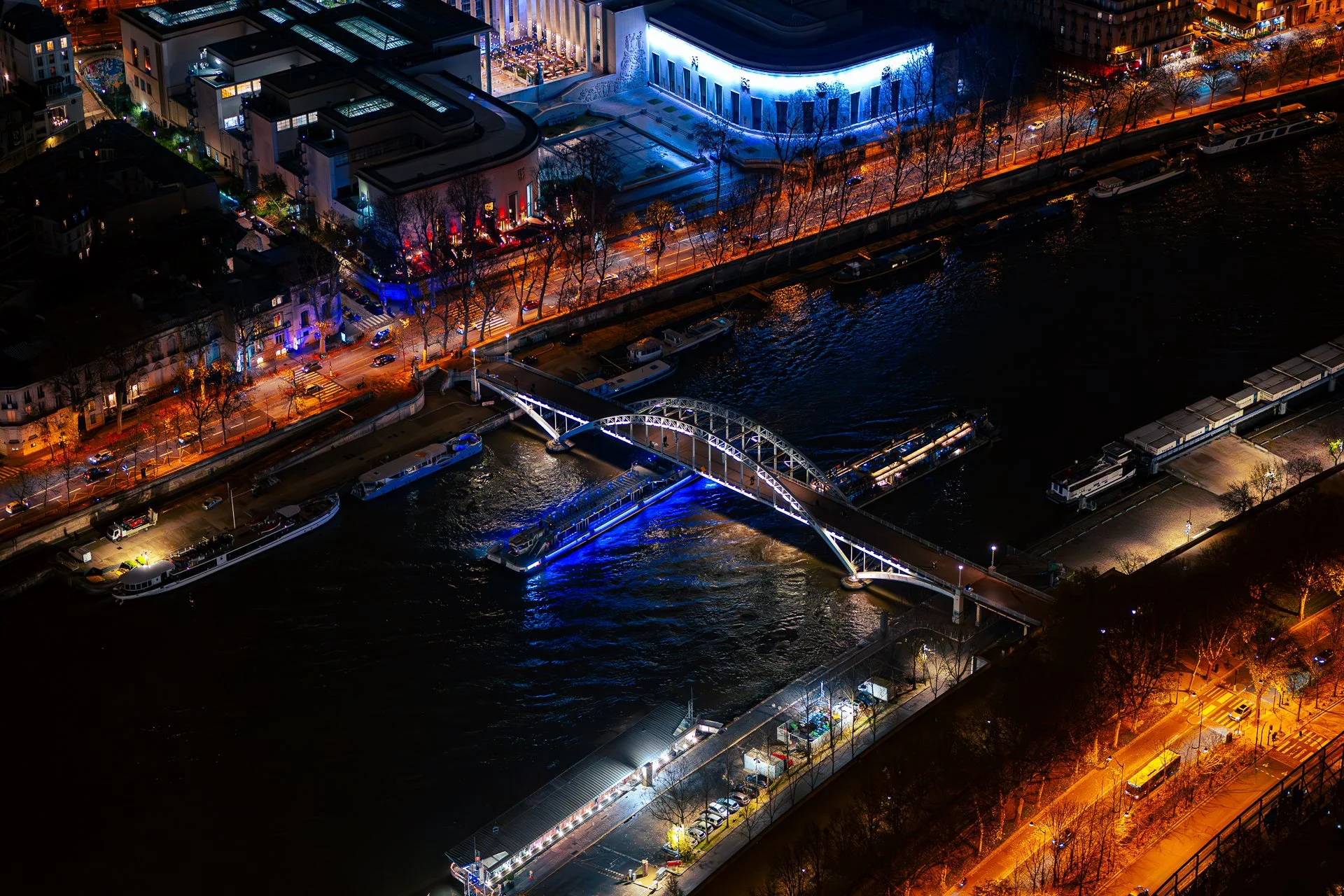 Night view of illuminated bridge over river in cityscape
