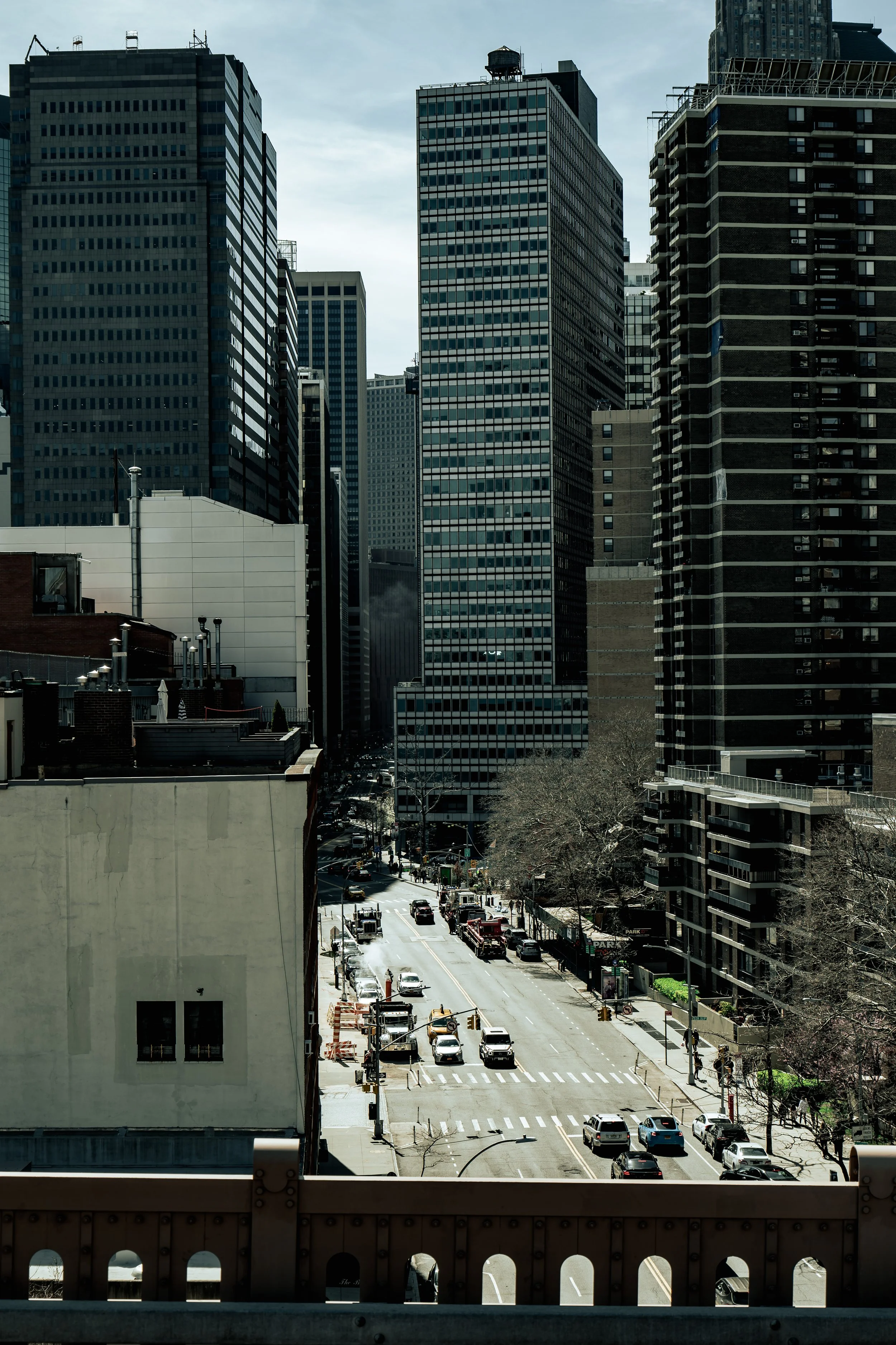 Urban street scene with tall buildings and cars in a city landscape.