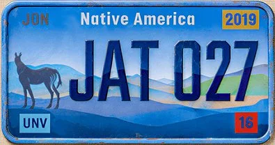 A blue license plate with mountains and a donkey silhouette, featuring the words 'Native America,' 'JAT 027,' and the year 2019.