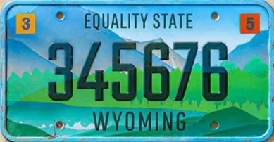 Wyoming license plate reading 345676 with state name and slogan, mountains in the background.