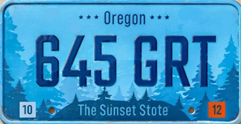 Oregon license plate with number 645 GRT, themed with a sunset and pine trees, and the slogan "The Sunset State."