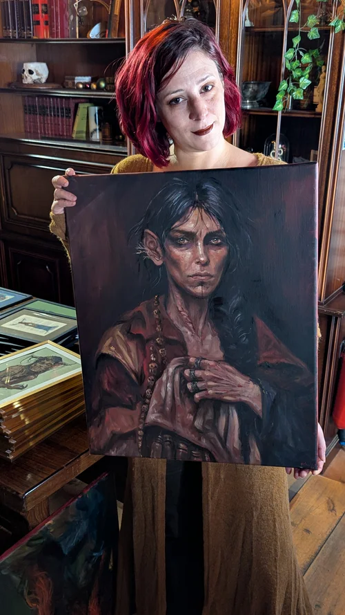 Rebecca tenant l’œuvre « Celle qui sauvait les voix ».