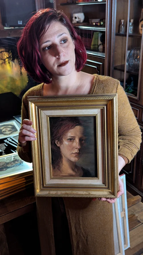 Rebecca tenant l’œuvre « Celle qui disparaîtra ».
