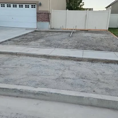 Residential driveway preparation showing the existing area cleared and ready for a new concrete pour.
