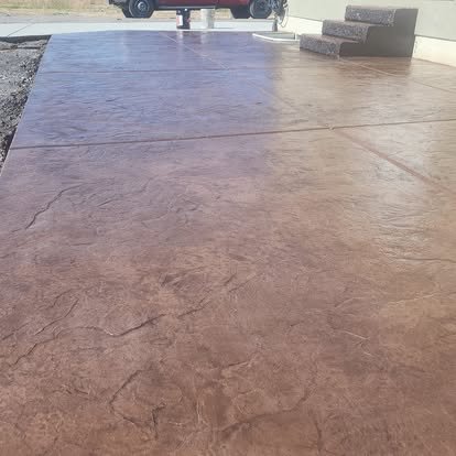 Finished decorative concrete patio with rich brown coloring, subtle texture, and a smooth sealed appearance.
