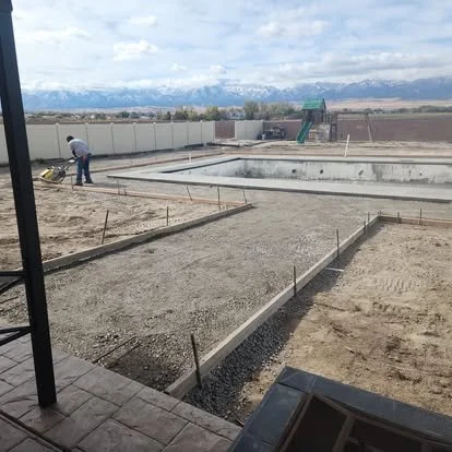 Concrete patio pool surround project in progress with forms and base preparation before the final pour.