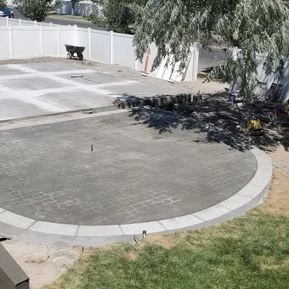 Finished decorative concrete patio with a rounded design, stamped texture, and clean border detail.