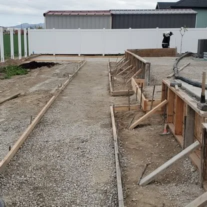 Walkway and patio preparation with forms and compacted base ready for concrete installation.
