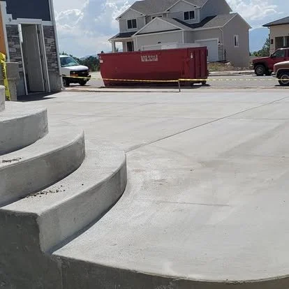 Finished concrete patio and rounded steps with a smooth surface and clean curved edges.