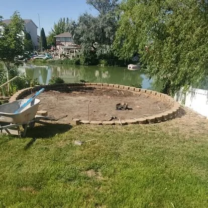 Backyard patio area before installation, showing the cleared circular layout ready for concrete work.