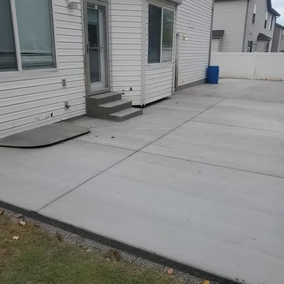 Completed backyard concrete patio and walkway area with clean control joints and a smooth residential finish.