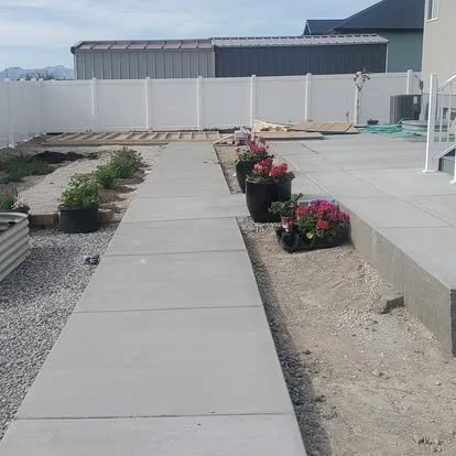Finished concrete walkway connecting the yard and outdoor living areas with clean lines and a smooth finish.