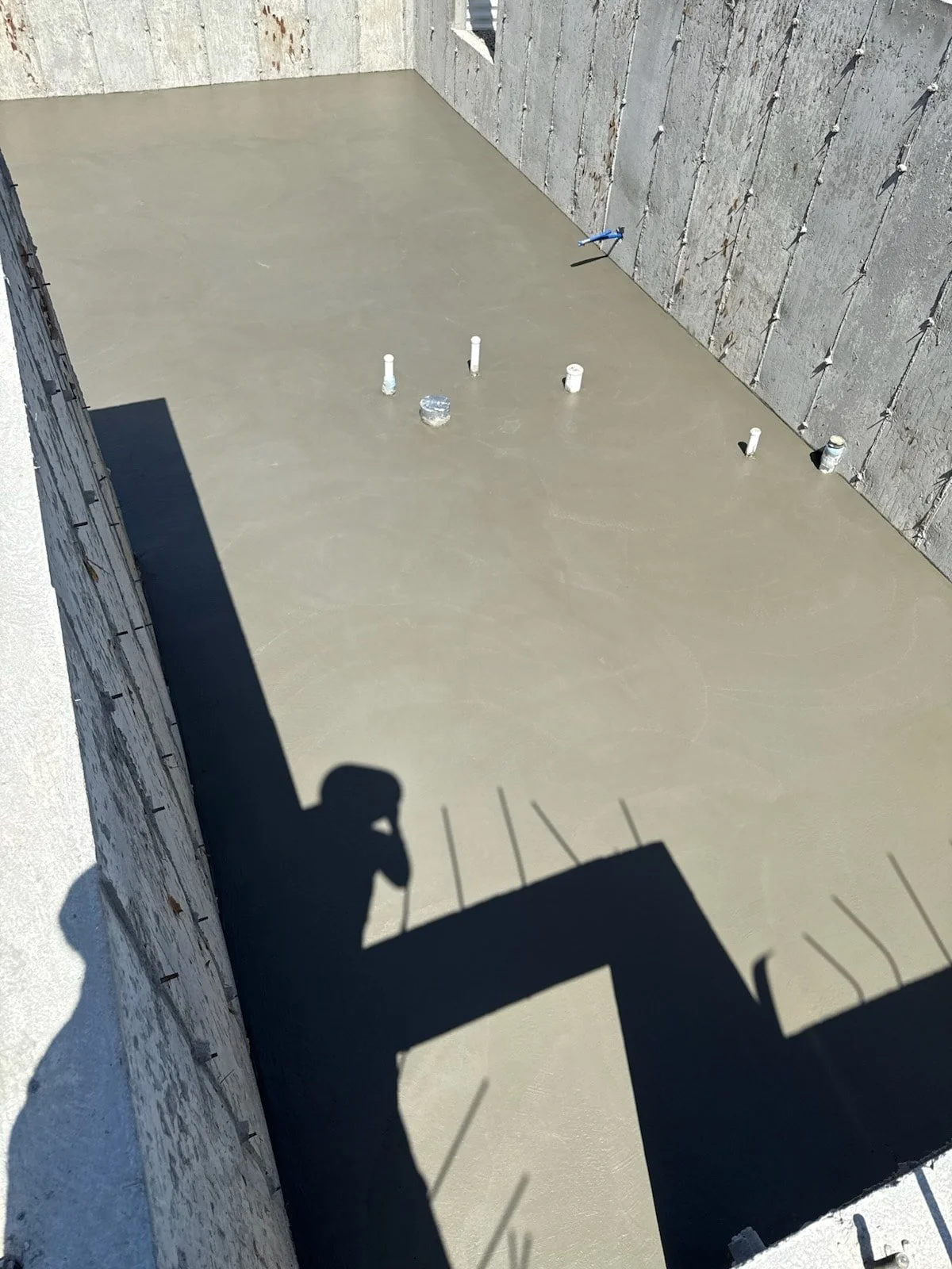 Finished concrete basement or foundation slab with plumbing rough-ins and a smooth, clean surface.