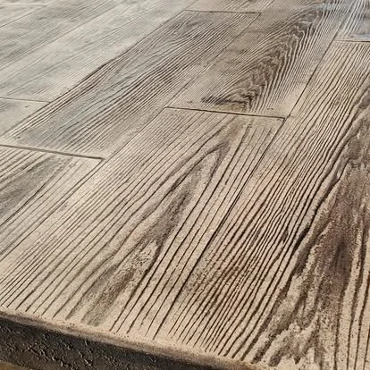 Close-up of wood plank stamped concrete showing realistic grain texture and detailed decorative finish.