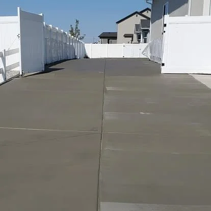 Finished side-yard concrete pad with clean control joints and a smooth residential finish.