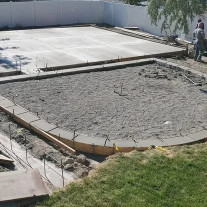 Concrete patio preparation with forms set, gravel base installed, and the area ready for a new pour.